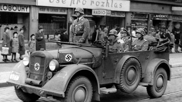 &quot;Vše pro rozhlas&quot;: auto s policejním šéfem a říšským sekretářem protektorátu K. H. Frankem (sedící vzadu) jede kolem obchodu s rozhlasovými přijímači, po 15. březnu 1939