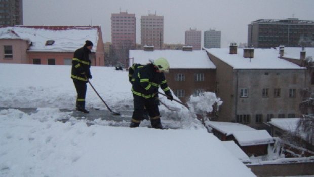 Hasiči odklízejí sníh ze střechy sportovní haly ve Frýdku-Místku
