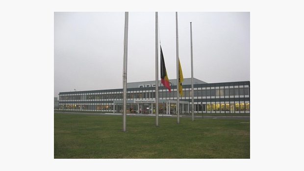 Vlajky před továrnou Opel v Antverpách na půl žerdi.