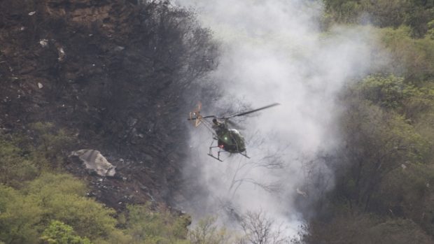 Helikoptéra záchranářů pročesává místo letecké katastrofy.