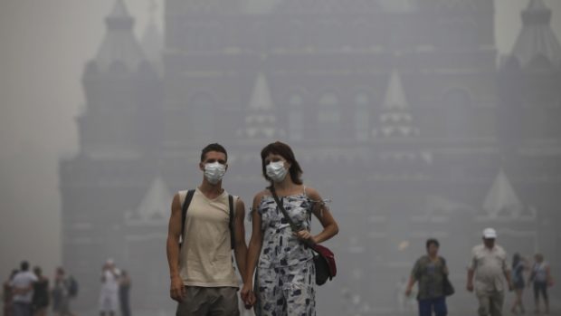 Lidé v Moskvě se smogu a kouři brání rouškami.