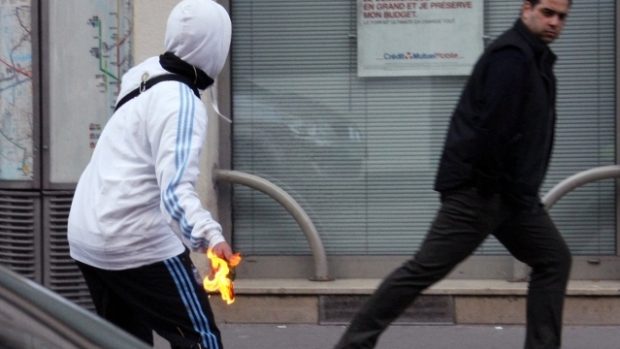 Protestující ve francouzském Lyonu hází zápalnou lahev do výlohy místní banky