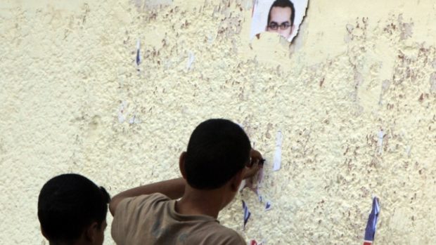 Strhávání plakátů kandidátů ze zdi v Káhiře svědčí o postoji mnoha Egypťanů k volbám..jpg