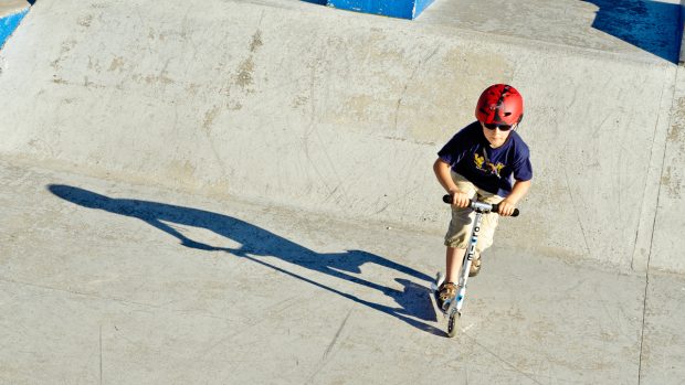 Dětské skatování s koloběžkou ve Strašnickém betonovém skateparku Parku Gutovka
