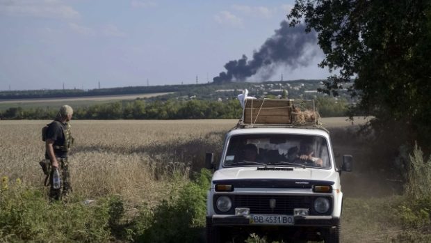 Ukrajinský voják sleduje obyvatele, kteří opouštějí vesnice v okolí Luhansku
