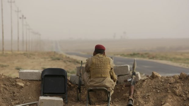 Kurdský bojovník vyhlíží pozice extremistů z Islámského státu nedaleko Mosulu