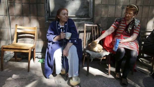 Žena sedí před svým domem v Doněcku