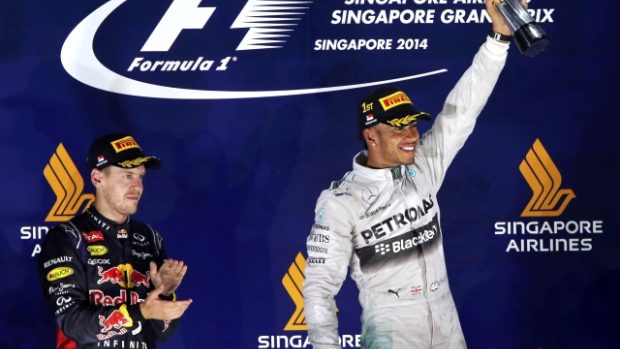 Lewis Hamilton se raduje z vítězství ve Velké ceně Singapuru, vlevo druhý v pořadí Sebastian Vettel
