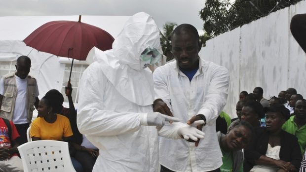 Dobrovolník v ochranném oděvu vyšetřuje podezření na nákazu eboly