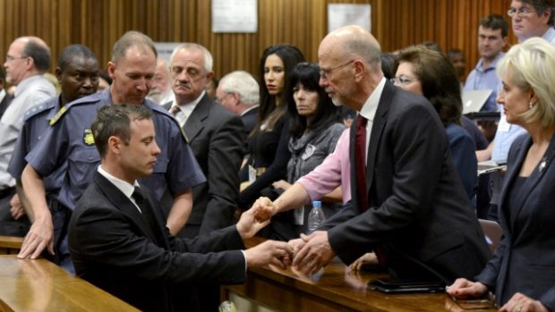 Oscar Pistorius se drží za ruce se členy své rodiny poté, co vyslechl rozsudek pěti let vězení za neúmyslné zabití přítelkyně