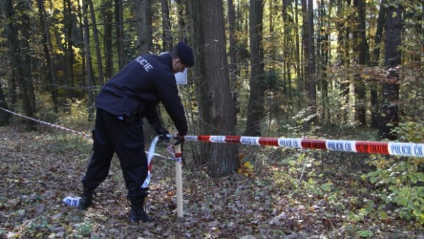 Policista upravuje pásku vymezující nepřístupný prostor v okolí muničního skladu ve Vrběticích na Zlínsku