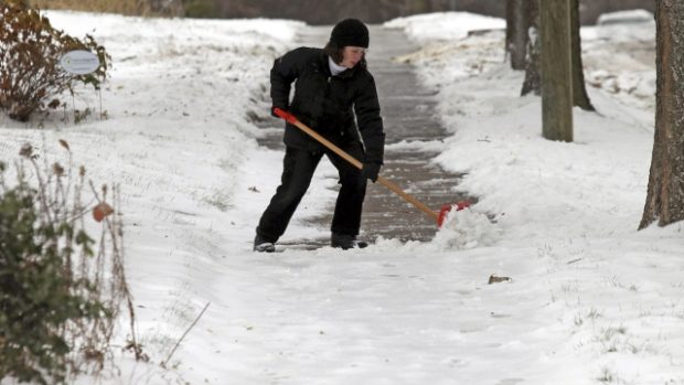Žena odklízí sníh v Minneapolisu. Většinu USA zasáhly sněhové přívaly nečekaně brzy. Listopad 2014