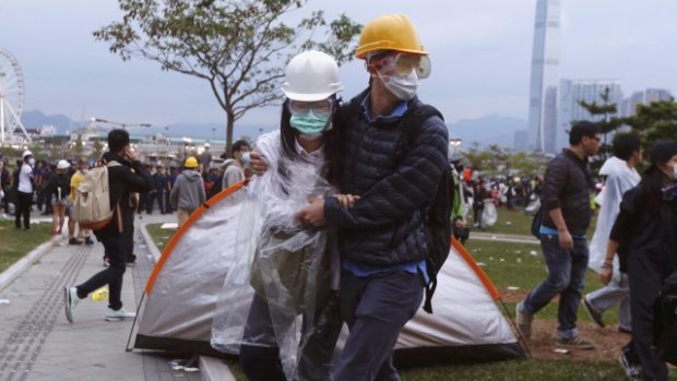 Prodemokratičtí aktivisté po střetech s pořádkovou policí opouštějí místo protestu u sídla hongkongské vlády