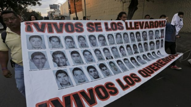 Lidé v Mexiku demonstrují za záchranu studentů. Plakát hlásá: „Vzali si je živé, zpátky je chceme živé.“