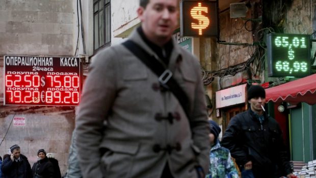 Lidé kráčejí kolem tabulí se směnnými kurzy v Moskvě