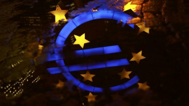 Znak eura odrážející se na hladině kaluže před bývalým sídlem Evropské centrální banky ve Frankfurtu nad Mohanem