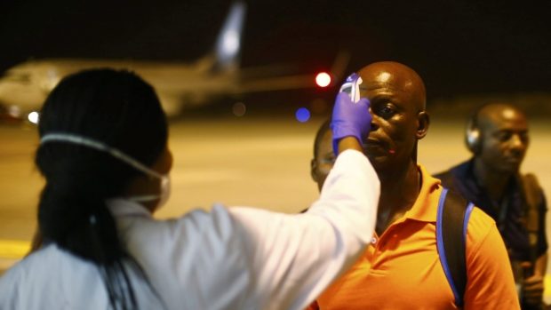 Rovníková Guinea. Zdravotník na letišti měří teplotu muži, který přicestoval do Baty. Opatření má snížit riziko šíření eboly v době konání afrického šampionátu v zemi