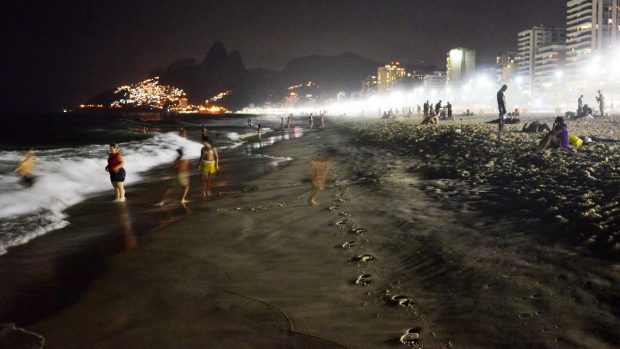 I dvě hodiny po setmění se lidé koupou na riodejaneirské pláži Ipanema. Teplota je příjemnější - místo denních čtyřicítek je 30 stupňů Celsia