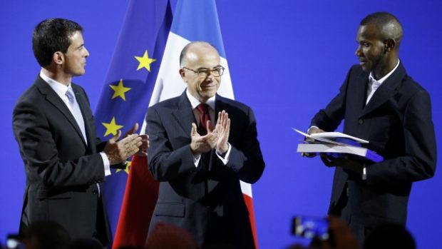 Francouzský premiér Manuel Valls (vlevo) a ministr vnitra Cazeneuve (uprostřed) předali Lassanu Bathilyovi doklady o udělení francouzského občanství