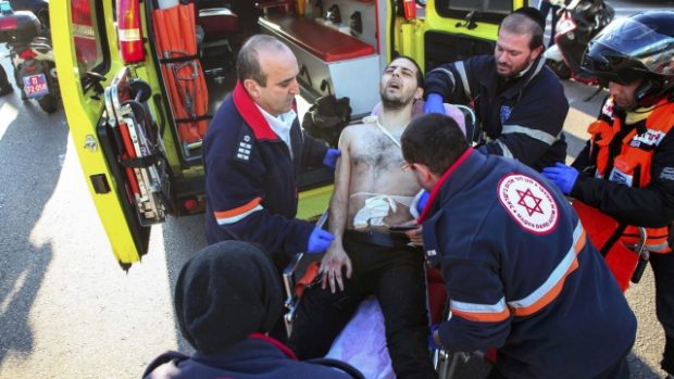 Izraelští zdravotníci odnášejí do sanitky jednoho ze zraněných, které v autobuse v Tel Avivu pobodal palestinský útočník