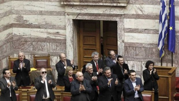 Řecký premiér Alexis Tsipras (vpravo) a členové jeho vlády tleskají po úspěšném hlasování o důvěře