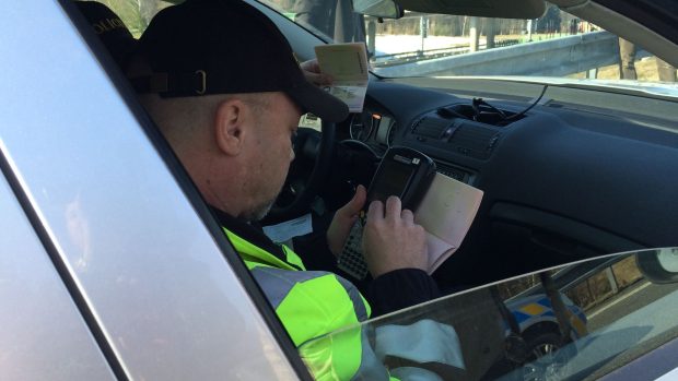 Policisté kontrolují doklady cizinců z osobního auta