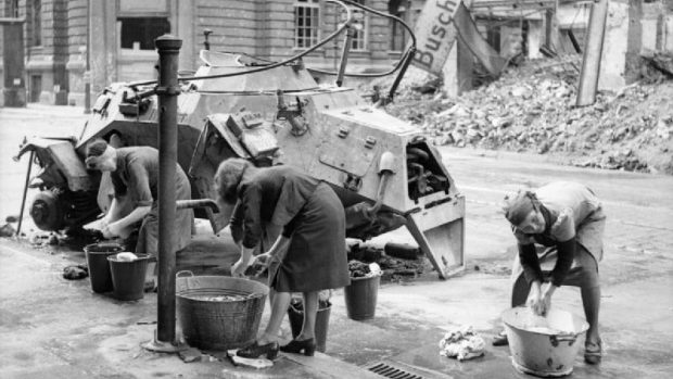 Německé ženy perou u pumpy v rozbombardovaném Berlíně prádlo, červenec 1945