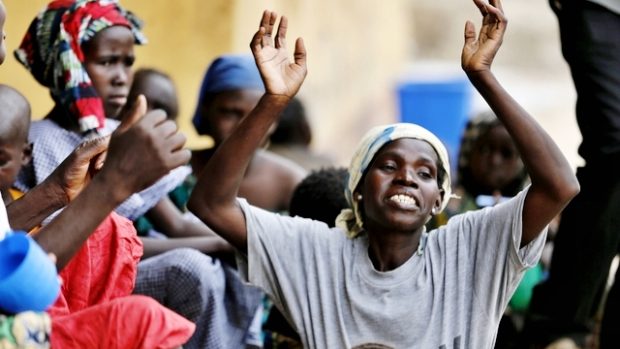 Jedna ze zachráněných nigerijských žen oslavuje svobodu v uprchlickém táboře u města Yola