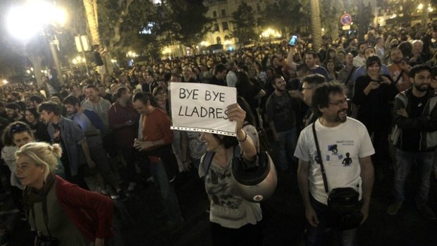 Příznivci španělské levice slaví vítězství v komunálních a místních volbách. Žena drží transparent s nápisem &#039;sbohem zloději&#039;