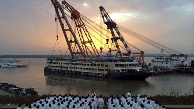 Záchranáři přihlížejí, jak je vrak lodi vyzvedáván z hlubin řeky Jang-c-ťiang