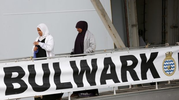 Zachránění uprchlíci opuštějí palubu britské válečné lodi Bulwark
