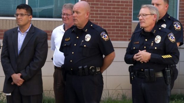 Policisté z města McKinney v Texasu včetně náčelníka Grega Conleyho (vpravo vpředu) naslouchají starostovi Brianu Loughmillerovi (snímek z videa)
