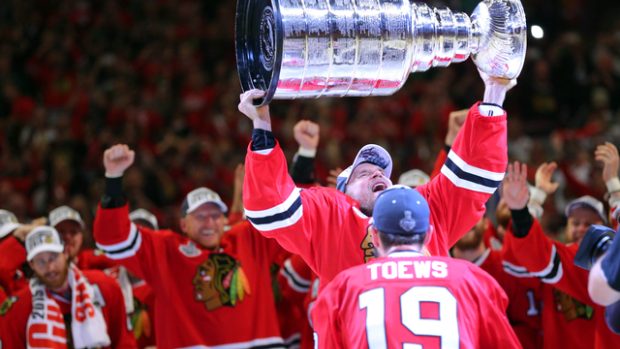 Obránce Chicaga Kimmo Timonen převzal Stanleyův pohár od kapitána Jonathana Toewse