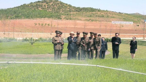 Severokorejský vůdce Kim Čong-un s doprovodem při obhlídce polí (arhcivní ilustrační foto)