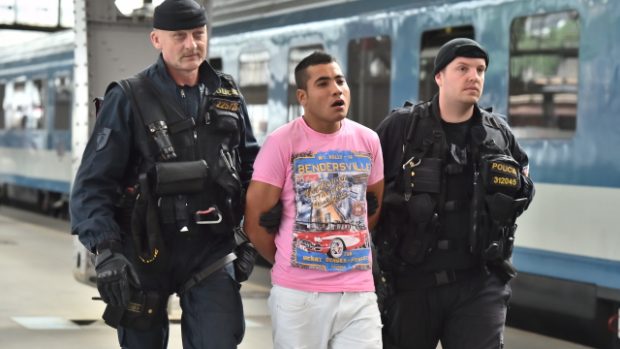 Policisté odvádějí z pražského hlavního nádraží na služebnu jednoho z nelegálních migrantů