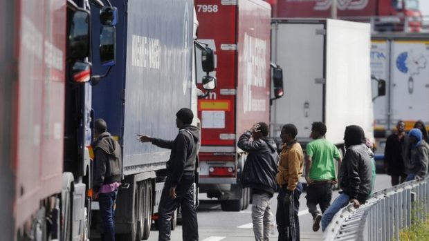 Skupiny migrantů se snaží dostat do kamionů čekajících na vjezd do tunelu pod kanálem La Manche