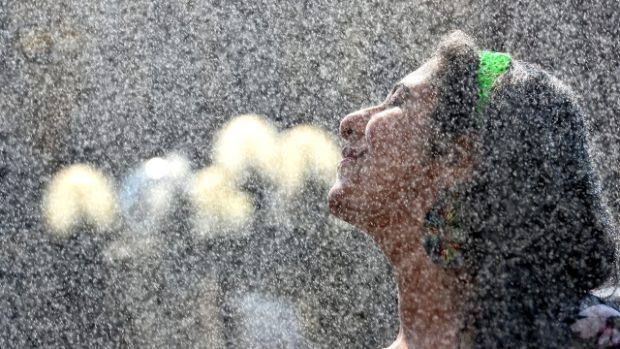 Mladá žena se osvěžuje na Staroměstském náměstí v Praze, kde odpoledne teplota vystoupala nad 38 °C