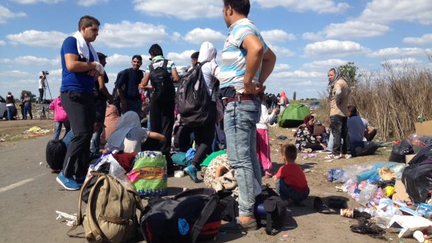 Migranti v Röszke na maďarsko-srbské hranici čekají na policejní autobus