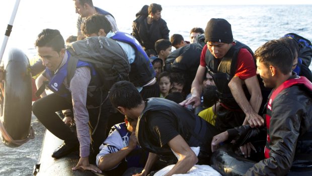 Běženci z Afghánistánu vystupují na ostově Lesbos z člunu (snímek z 8. 10. 2015)