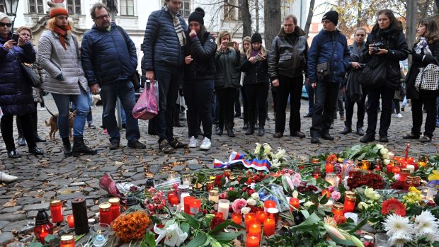 Lidé přinášejí květiny a svíčky k francouzskému velvyslanectví