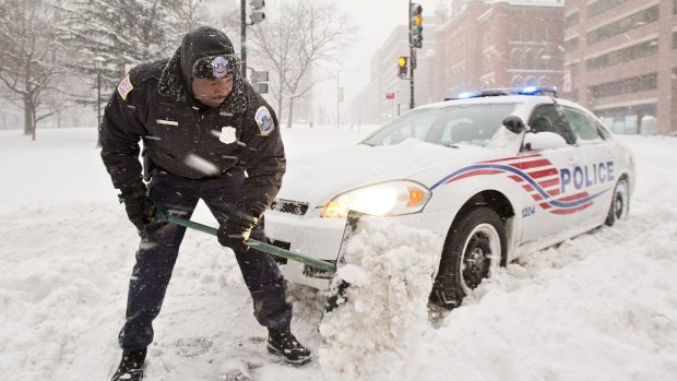 Washingtonský policista se snaží vyprostit svůj automobil ze sněhové pasti
