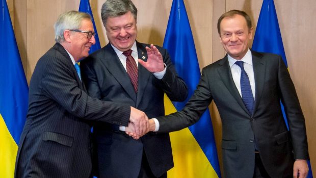 Ukrajinský prezident Porošenko (uprostřed) si potřásá rukou s šéfem Evropské komise Junckerem (vlevo) a předsedou Evropské rady Tuskem