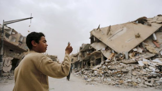 Chlapec si fotí zničené budovy v Palmýře