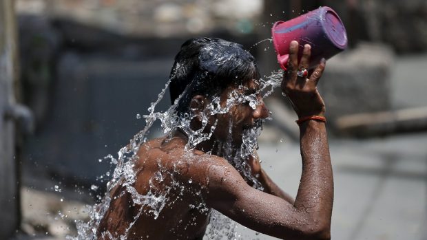 Indie se potýká s vedry. Na snímku z Bombaje muž osvěžující se vodou