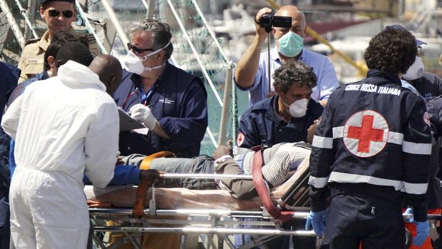Italští záchranáři ošetřují jednoho ze zachráněných běženců