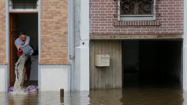 Muž vylévá vodu ze svého domu v zatopeném předměstí Villeneuve-Triage v Villeneuve Saint-Georges