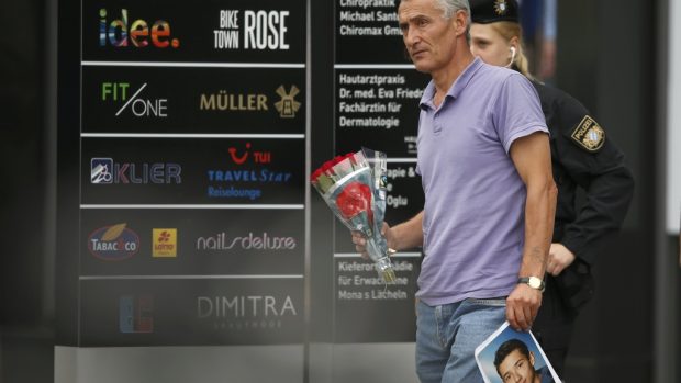 Lidé přinášejí k obchodnímu centru v Mnichově květiny