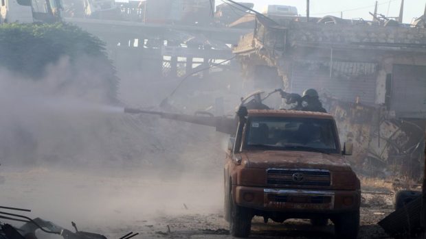 Bojovníci povstalecké Svobodné syrské armády v Aleppu pálí ze zbraně v autě