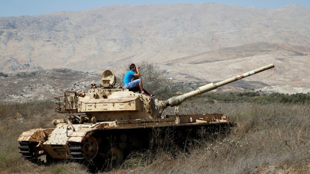 Muž ze starého tanku sleduje boje v Sýrii (Izraelem kontrolovaná část Golanských výšin, den před vyhlášením příměří).