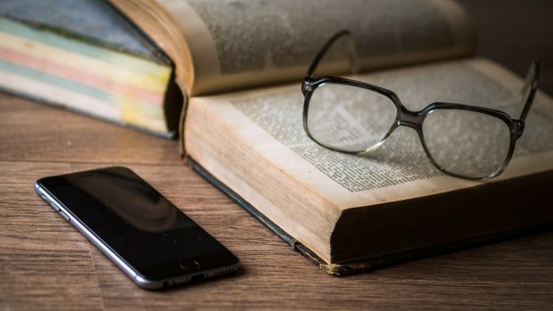 Brýle, kniha a mobil (ilustrační foto)